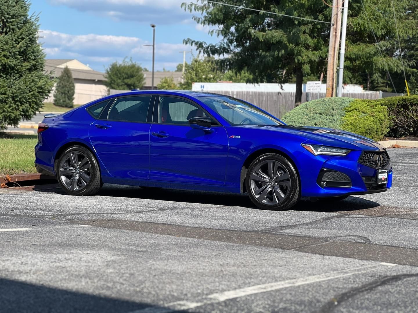 A blue car is parked in a parking lot.