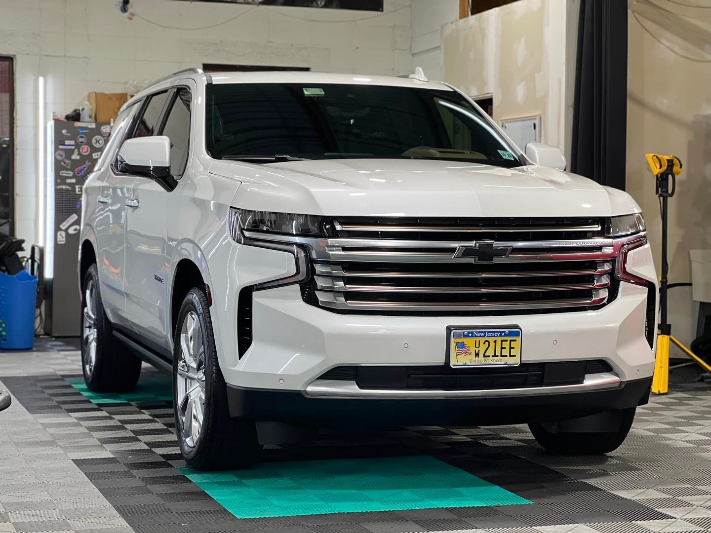 a white suv with a new york license plate is parked in a garage .