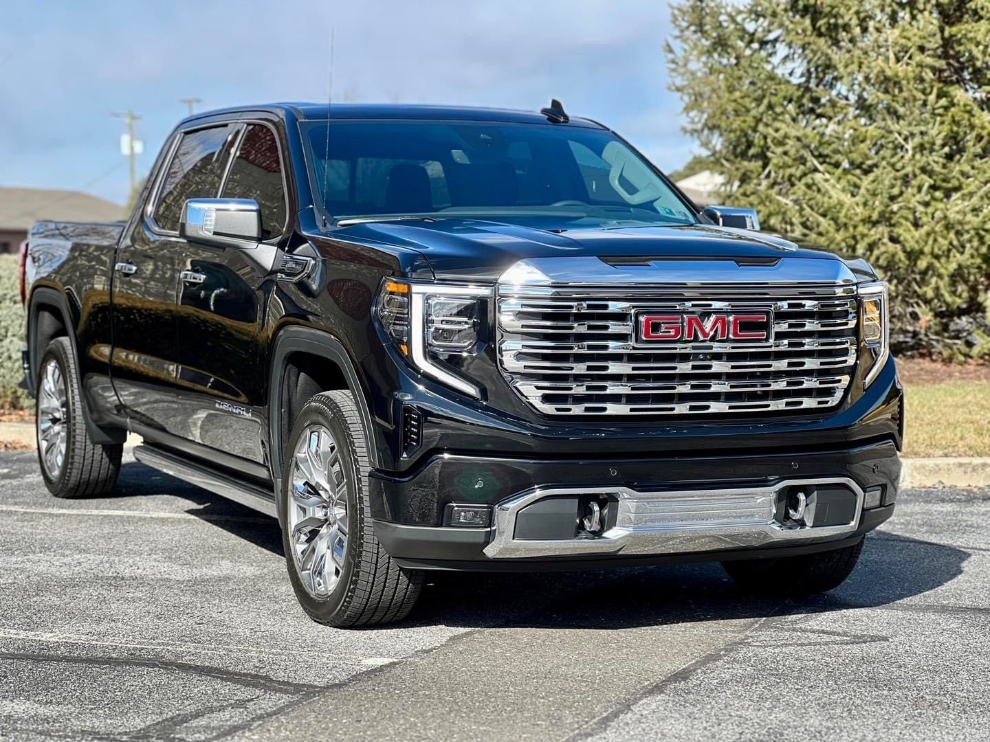 A black gmc truck is parked in a parking lot.