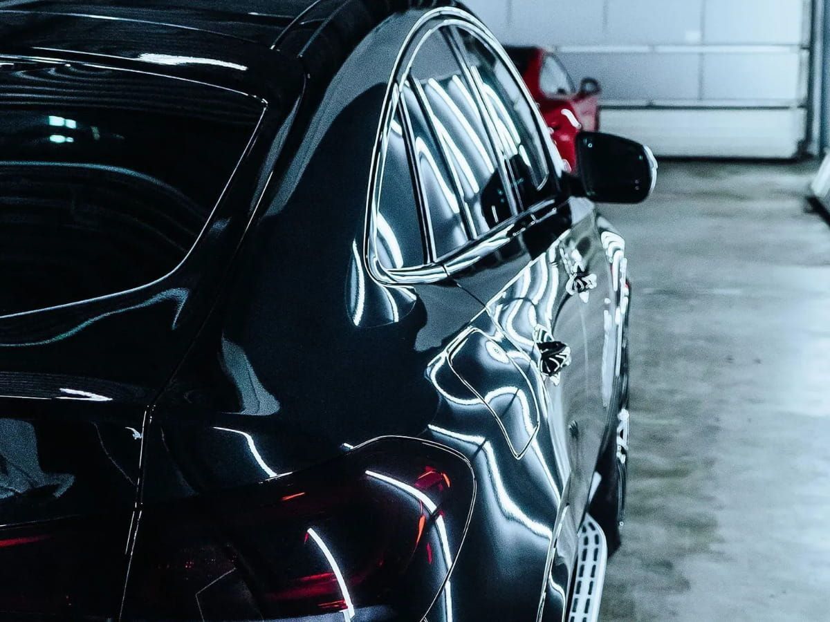Close-up of a glossy black vehicle showing reflective body panels.