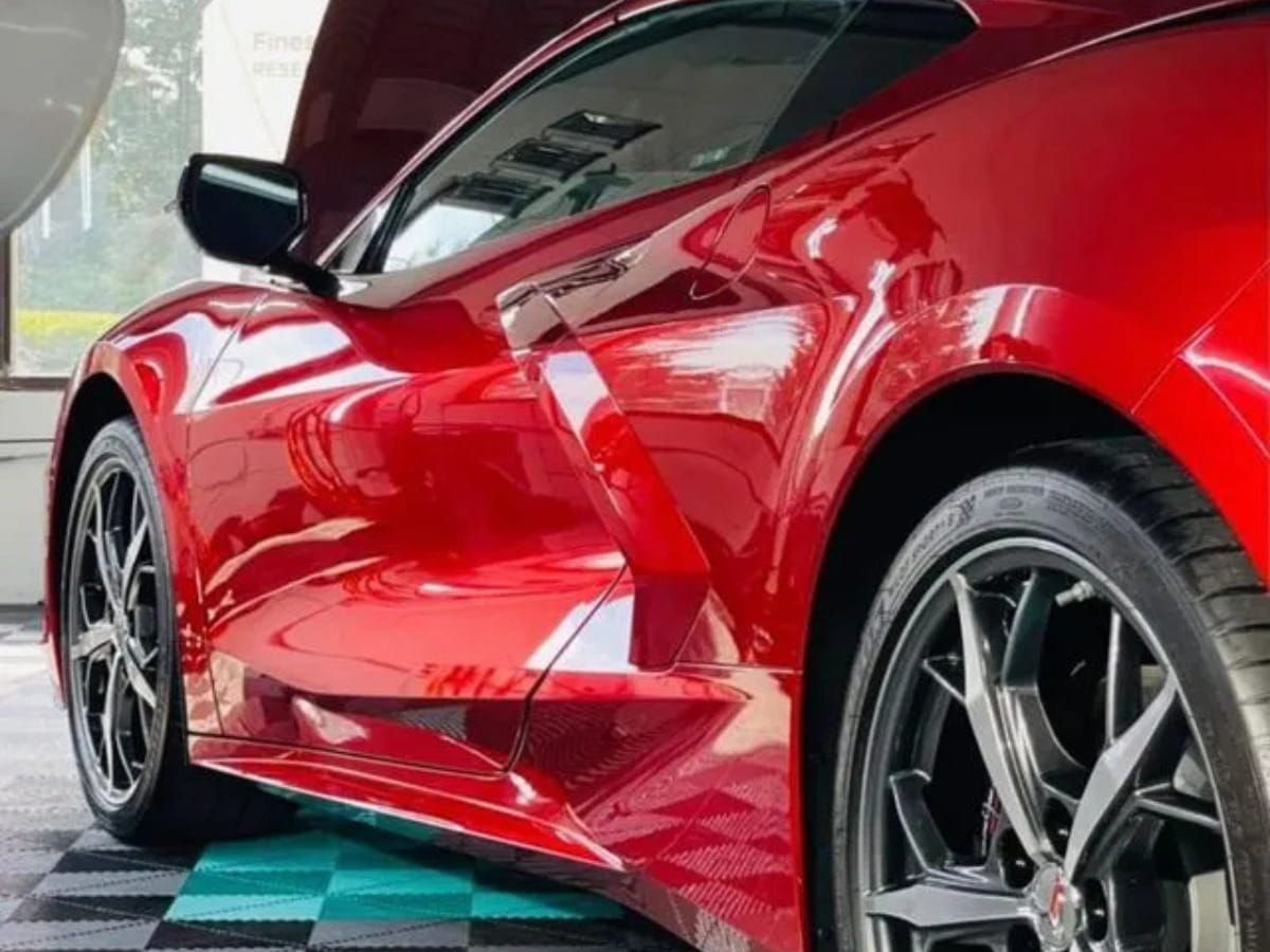 Red Chevrolet Corvette C8 with a glossy exterior inside the detailing facility.