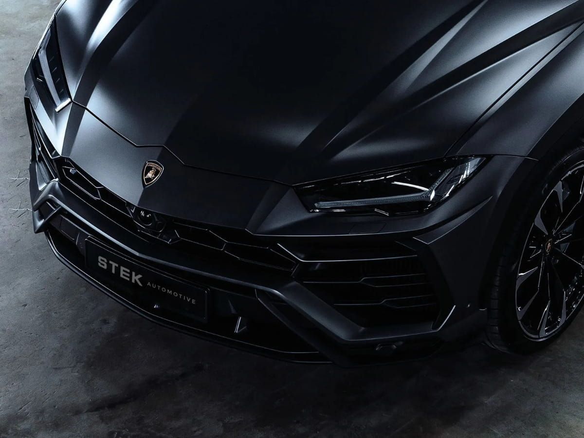 Black Lamborghini Urus with a glossy exterior finish and STEK branding.