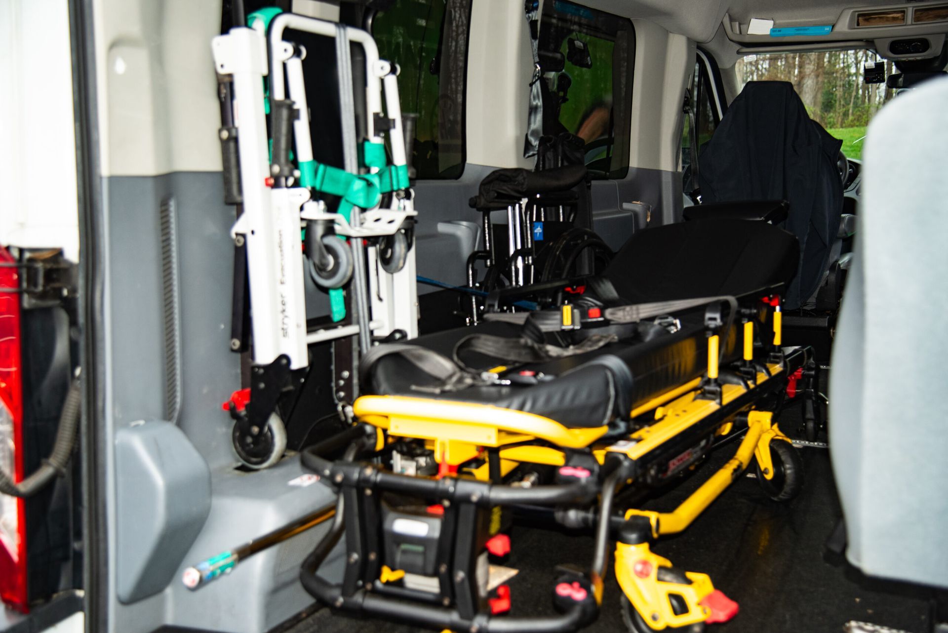 Folded stretcher and medical equipment inside an ambulance interior.