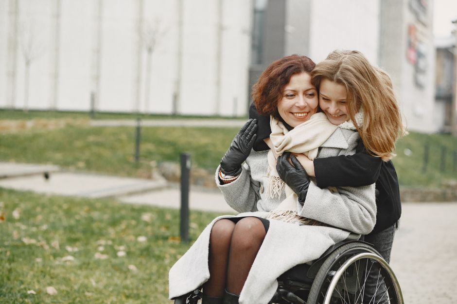 Parent helping a young child with a disability at home in Massachusetts