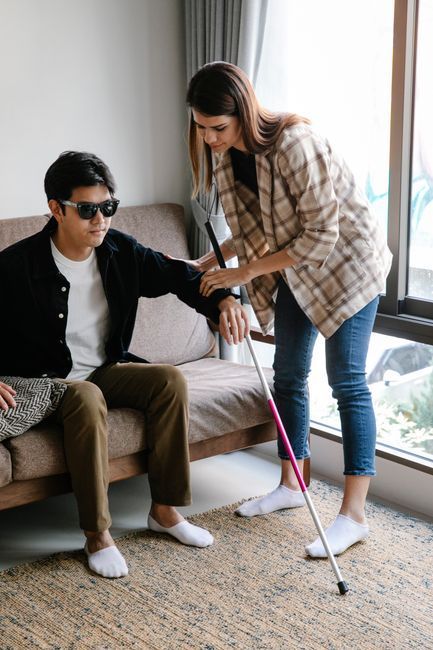 Home health aide steadying an older man as he walks after a stroke
