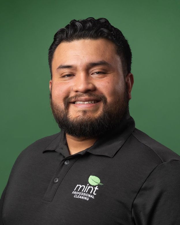 Mint crew member operating a commercial floor scrubber