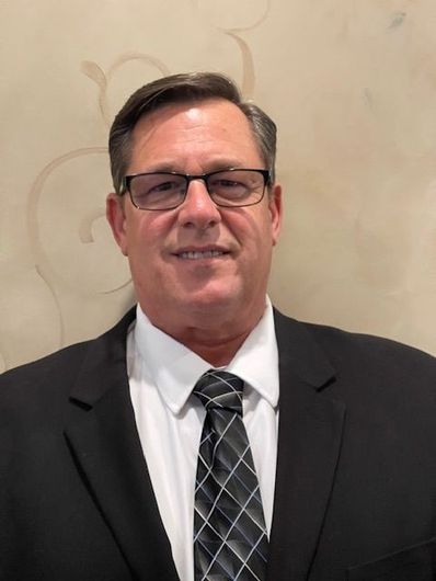 A man in a suit and tie is smiling for the camera.