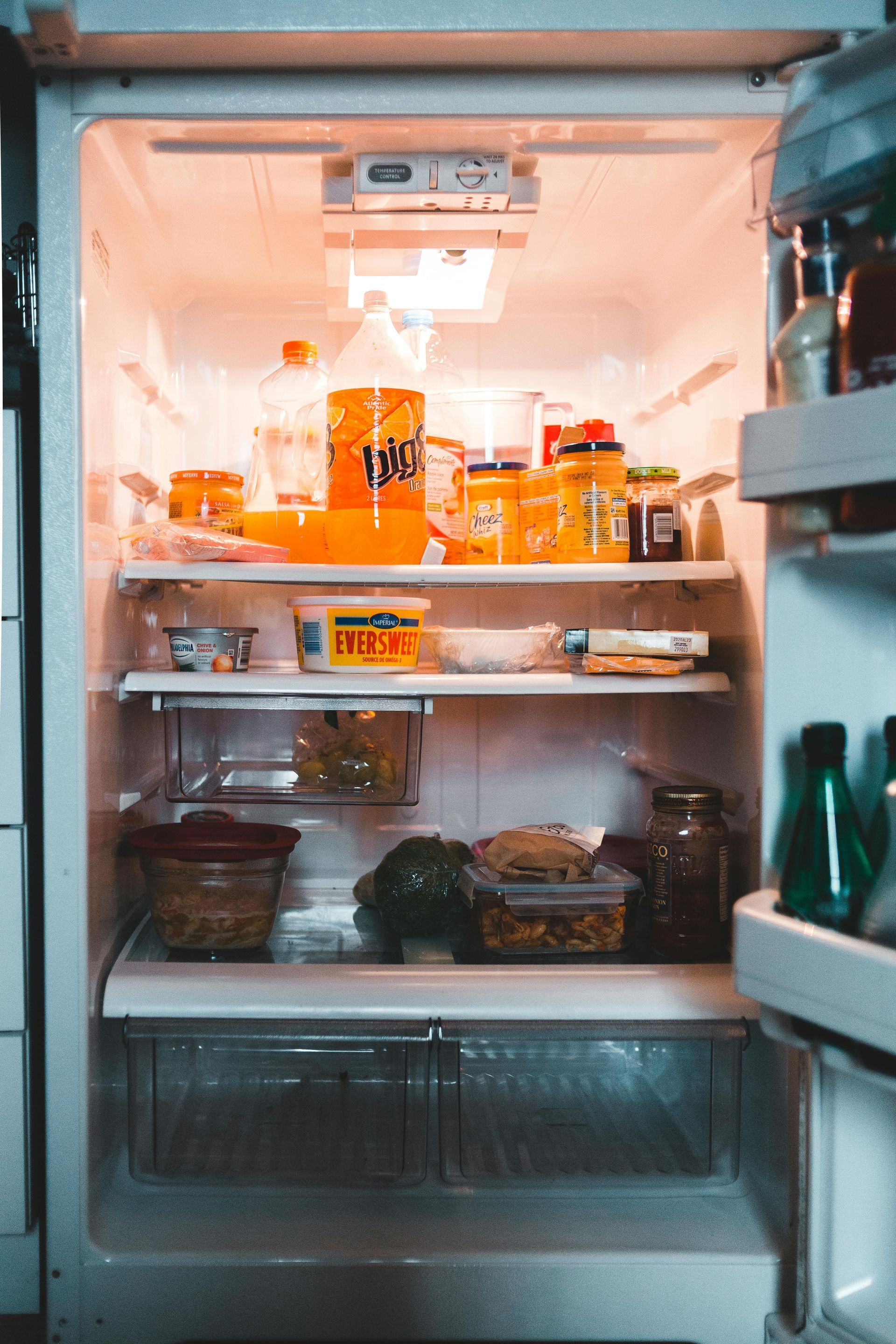 A modern kitchen features white cabinets, granite countertops, a stainless steel microwave and stove, and double windows.