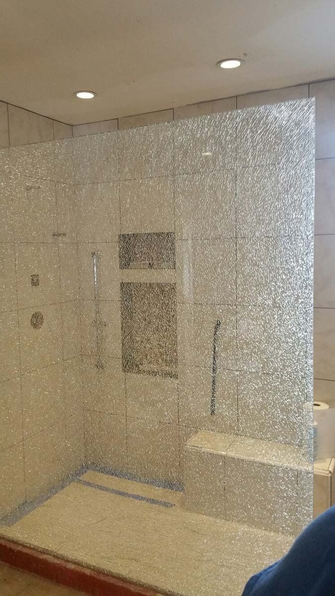 Shower with mosaic tile walls and built-in bench, recessed shelf.