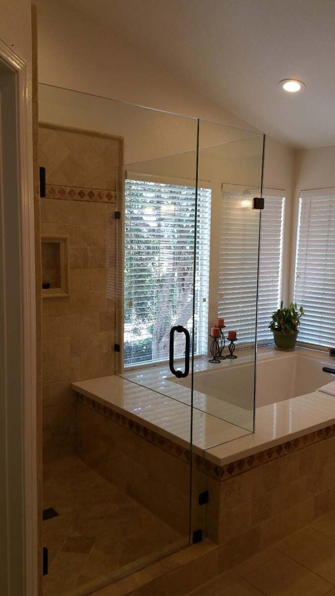 Bathroom vanity with large mirror, white countertop, windows, and a potted plant.