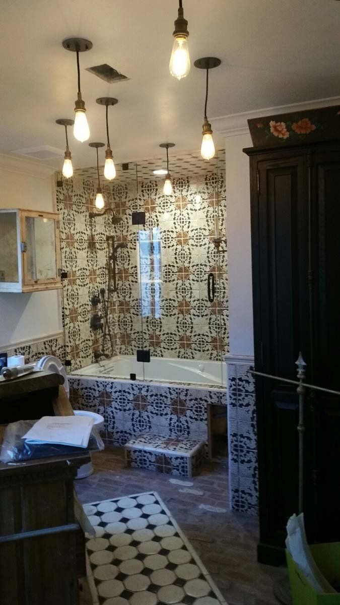 Cozy café interior with hanging lights, patterned curtains, and a tiled floor against dark cabinetry