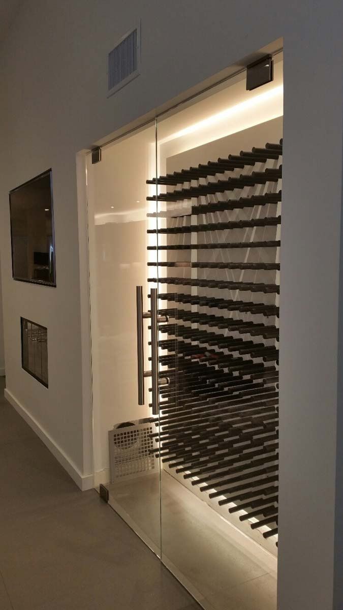 Illuminated glass doorway with horizontal dark slats in a modern hallway, next to a wall-mounted screen