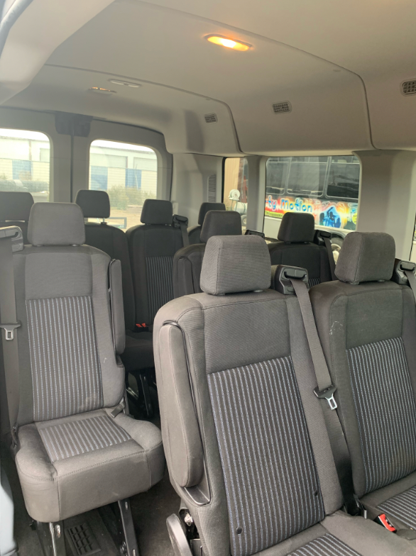 The inside of a van with a lot of seats and a window.