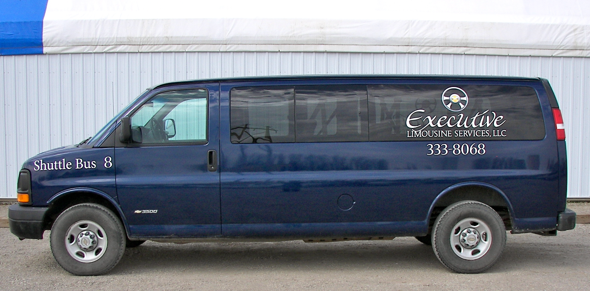 A blue van is parked in front of a building.