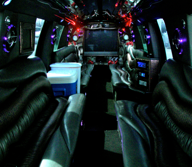 The inside of a limousine with a tv and coolers