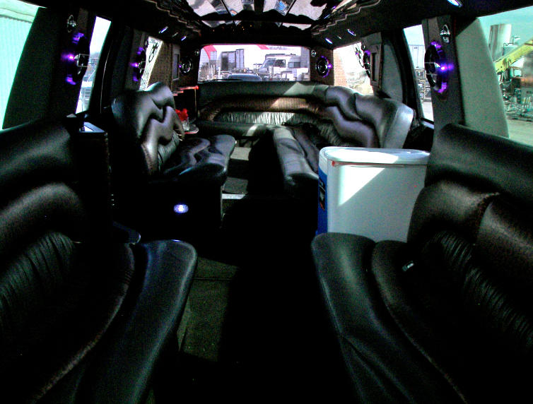 The inside of a limousine with purple lights on the ceiling