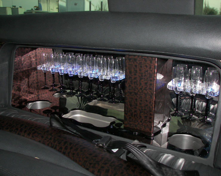 A row of wine glasses hanging from the ceiling of a car