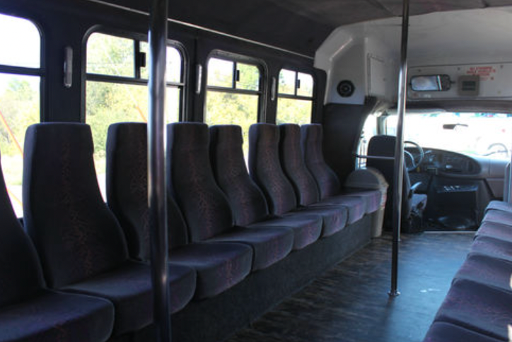 The inside of a bus with purple seats
