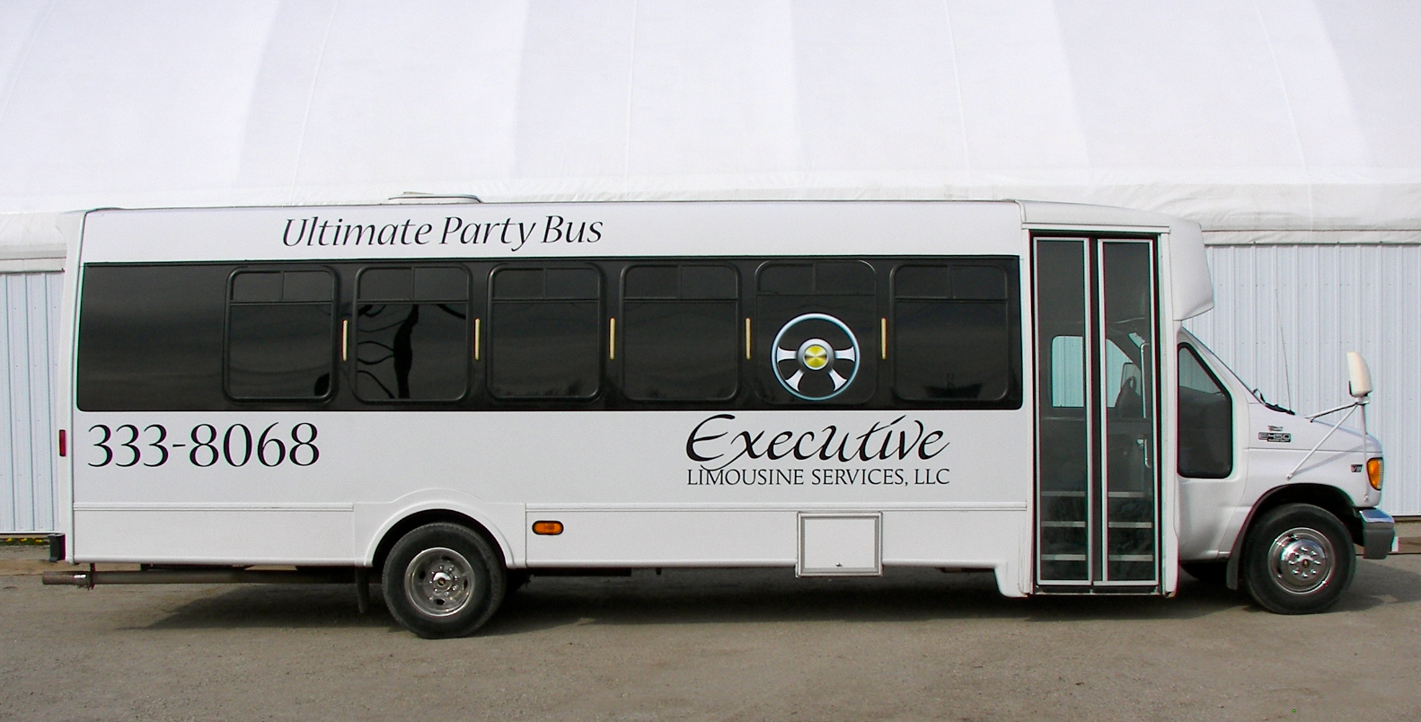 A white bus that says executive on the side