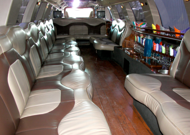 The inside of a limousine with brown and white leather seats