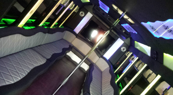 The inside of a limousine with a couch and a pole