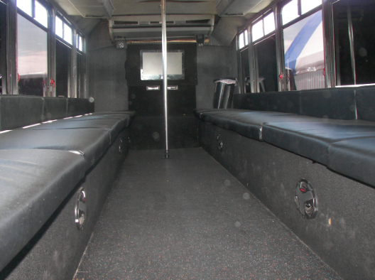 The inside of an empty bus with black seats