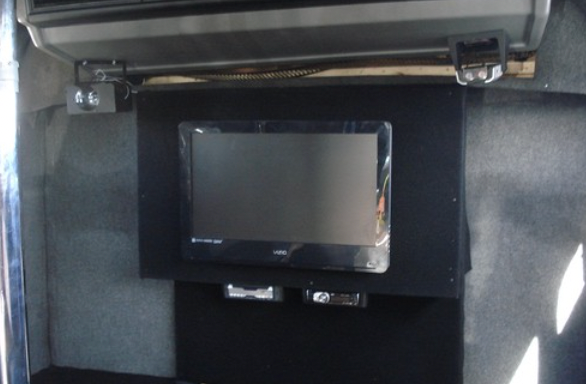 A flat screen tv is mounted to the ceiling of a room