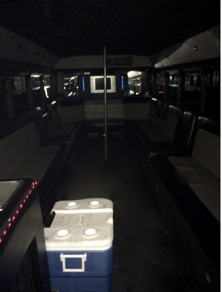 The inside of a bus with a blue cooler on the floor