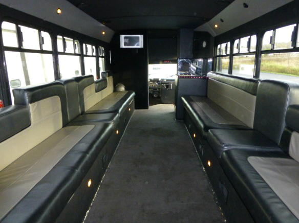 The inside of a bus with lots of seats and a tv