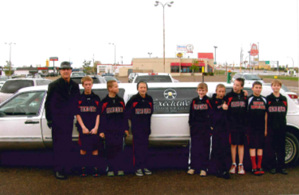 A group of kids standing in front of a white limousine