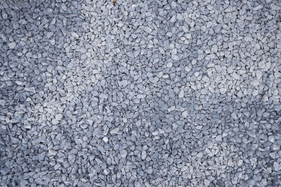 A pile of gravel is sitting on the ground. A pile of gravel is sitting on the ground.