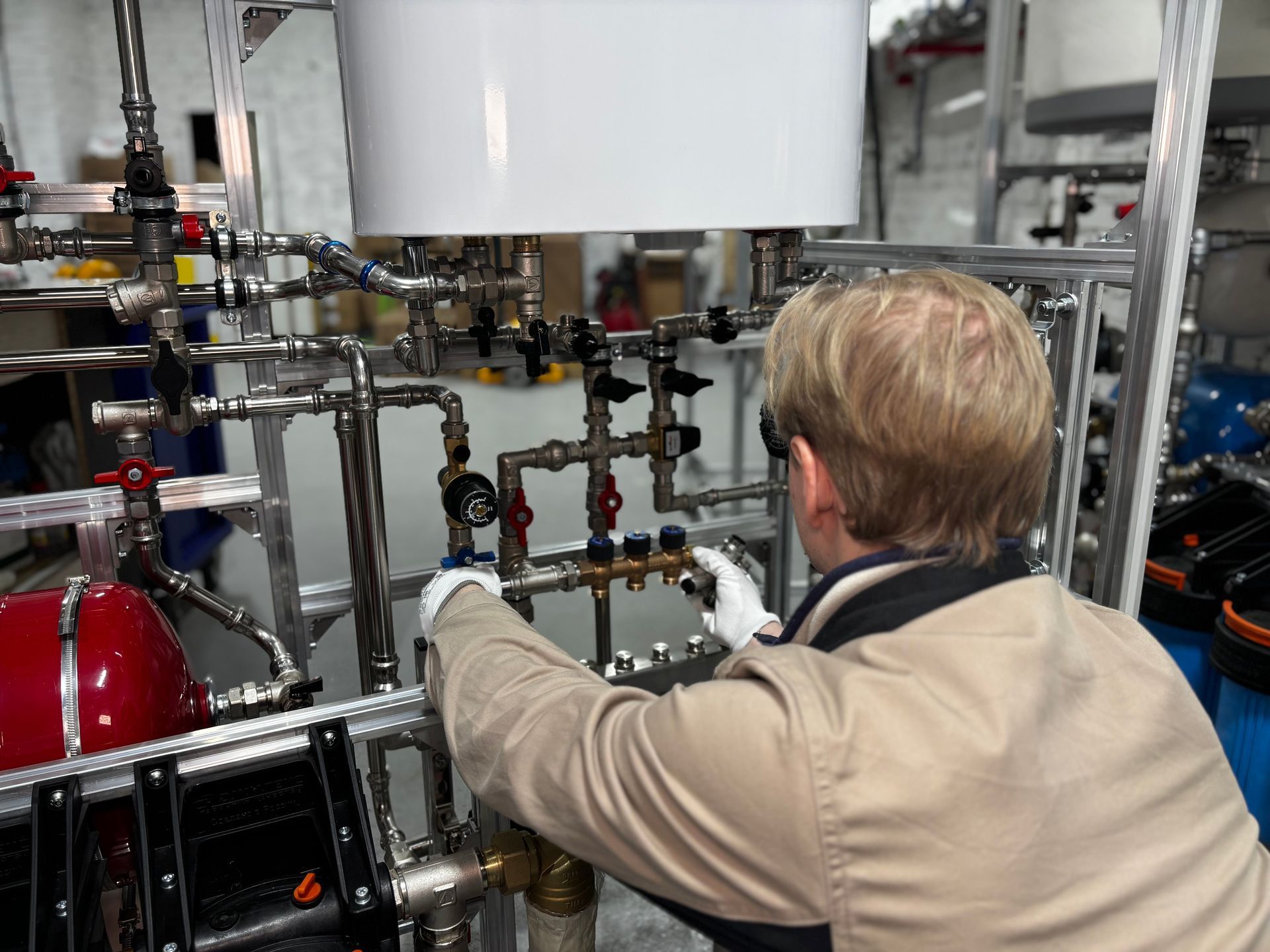 Person inspecting industrial pipes and valves in a mechanical facility