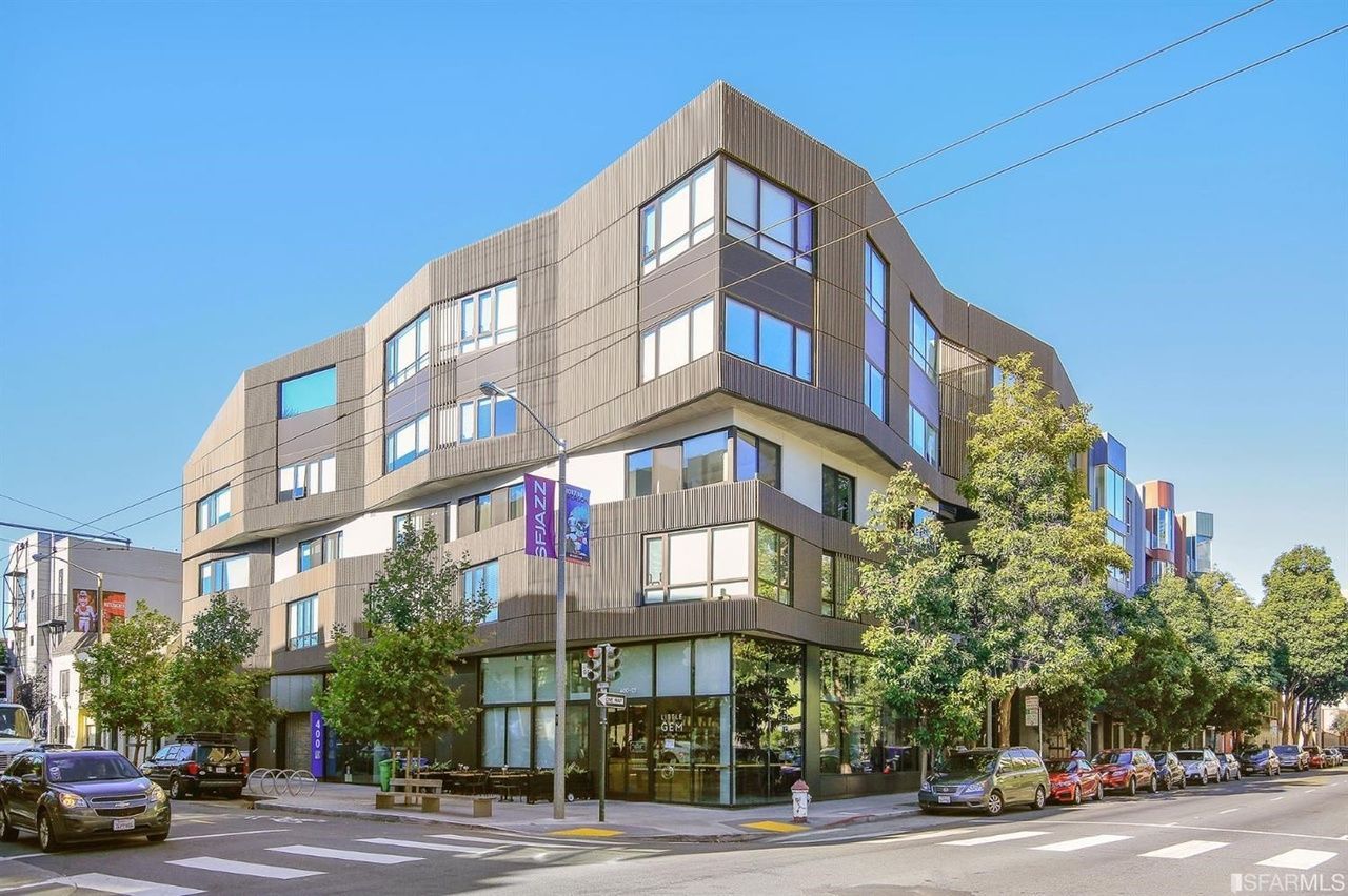 Modern corner office building with large windows on a tree-lined city street