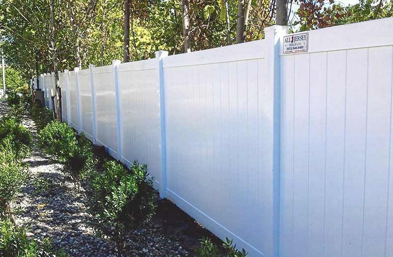 White Vinyl Fence is Surrounded by Trees — Clifton, NJ — All Jersey Fence Co.