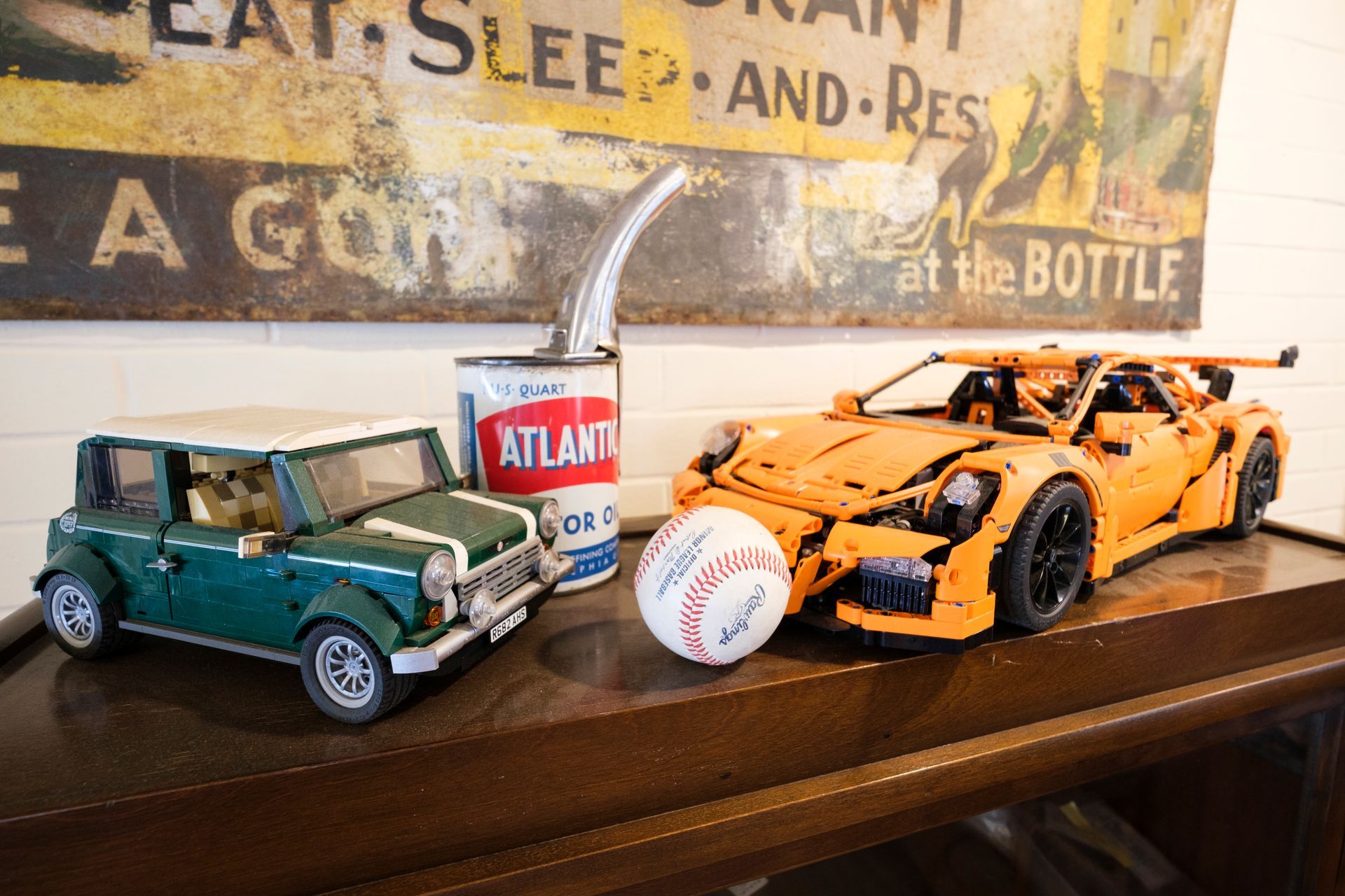 Mini Cooper and orange Porsche LEGO cars next to a baseball and a rusty sign. | Boalsburg Car Co.