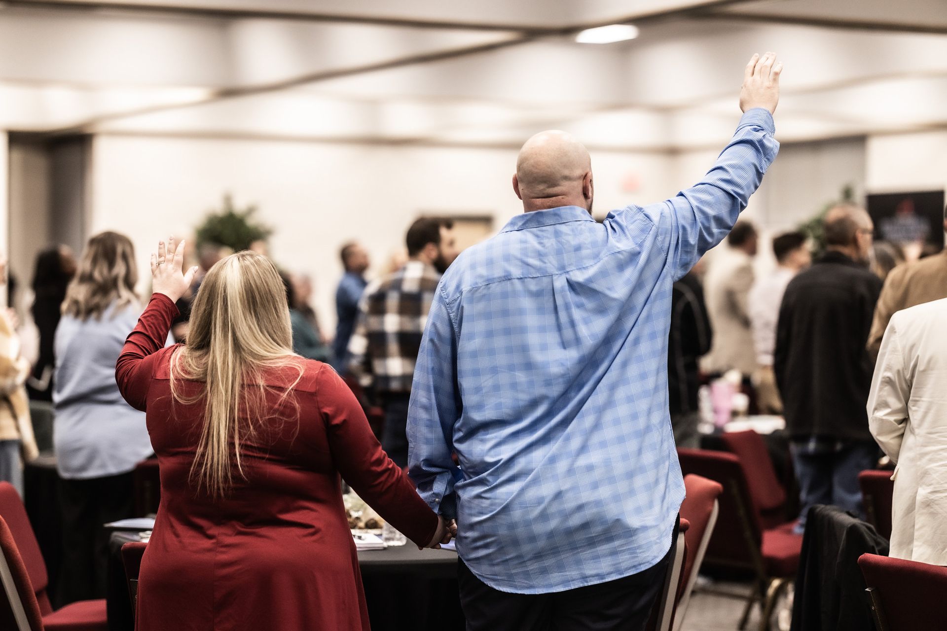 A man and a woman are holding hands and raising their hands in the air.