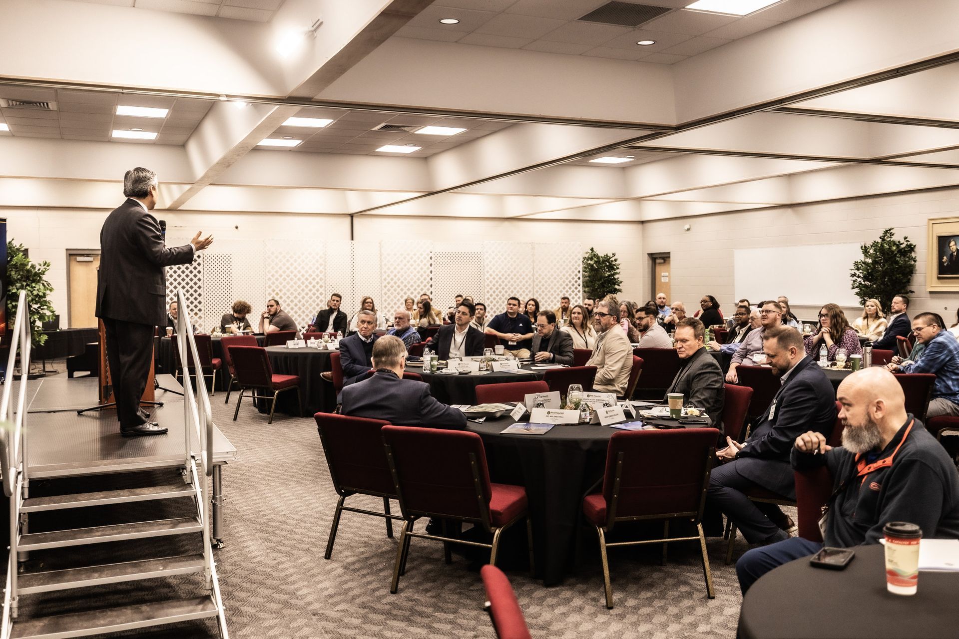 A man is giving a presentation to a large group of people in a conference room.