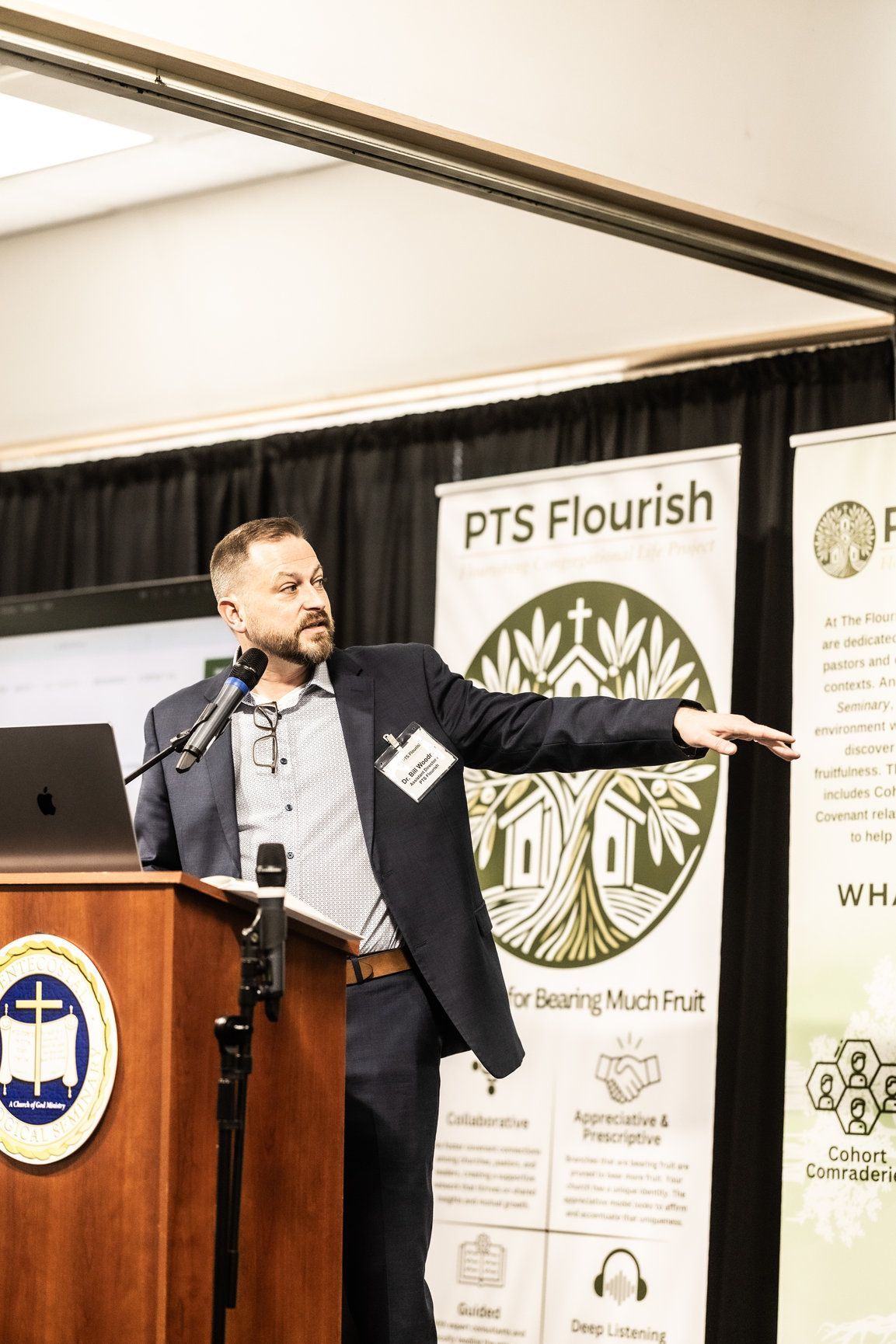 A man in a suit is standing at a podium giving a presentation.