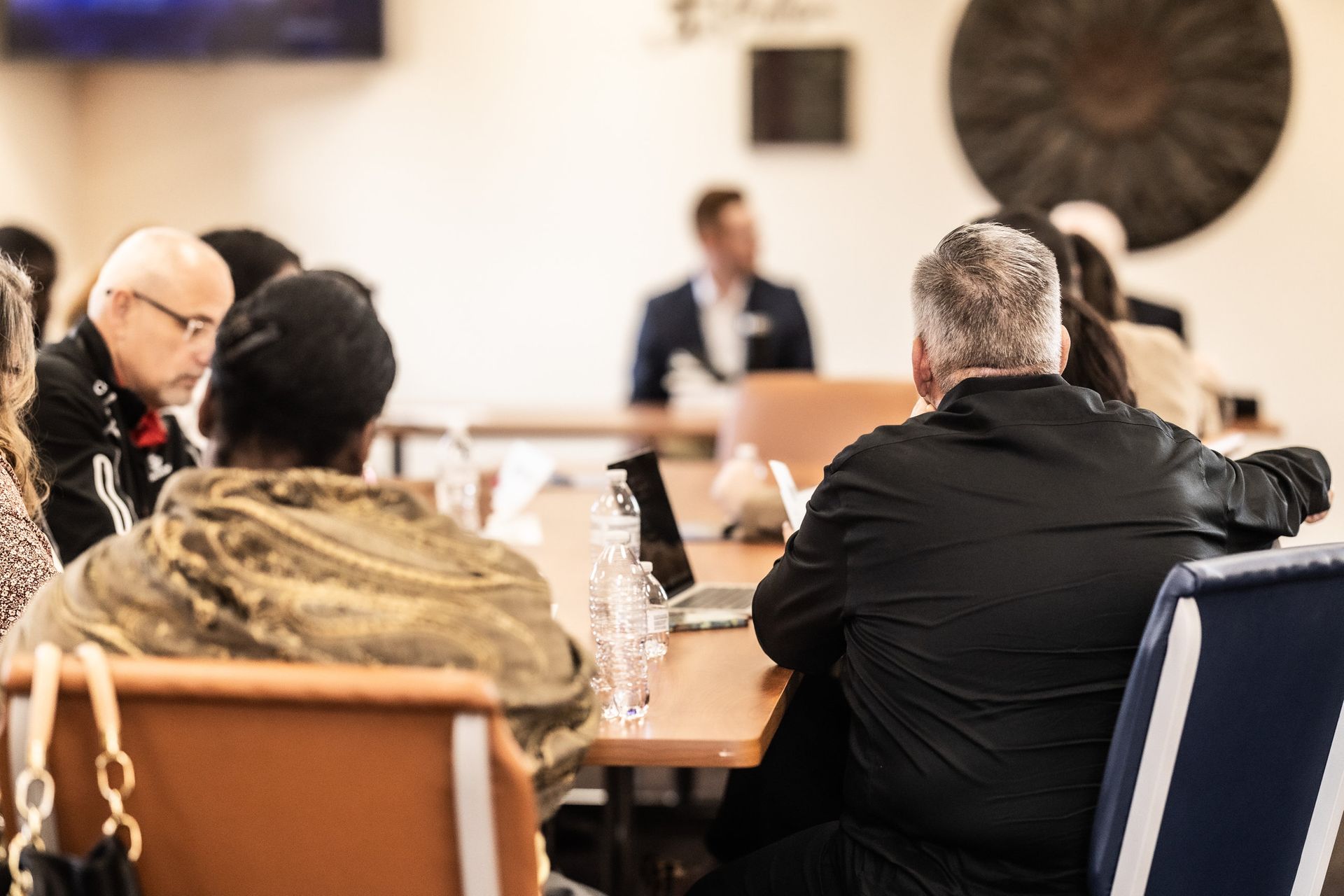 A group of people are sitting at a table in a conference room.
