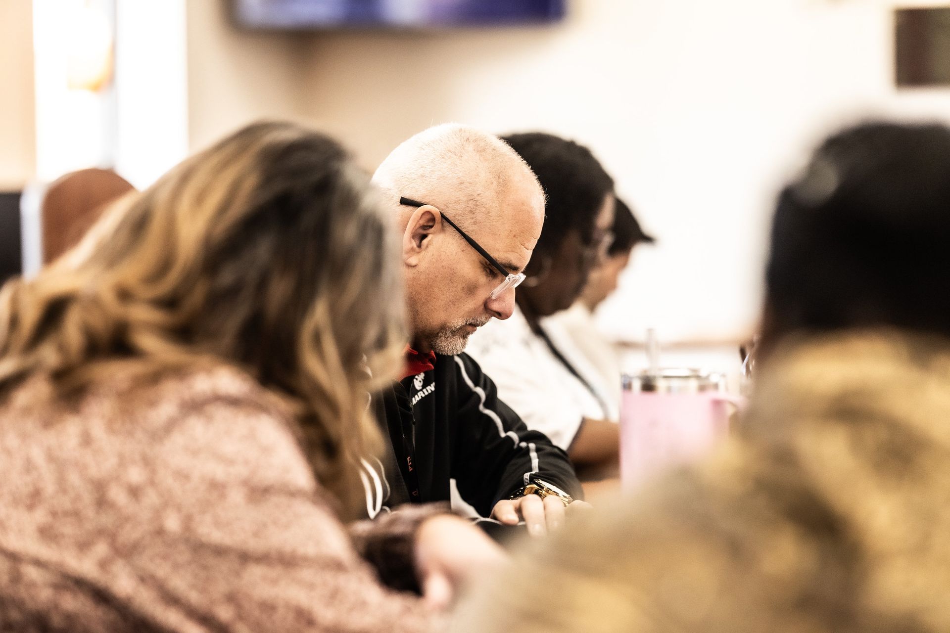 A group of people are sitting at a table in a room.