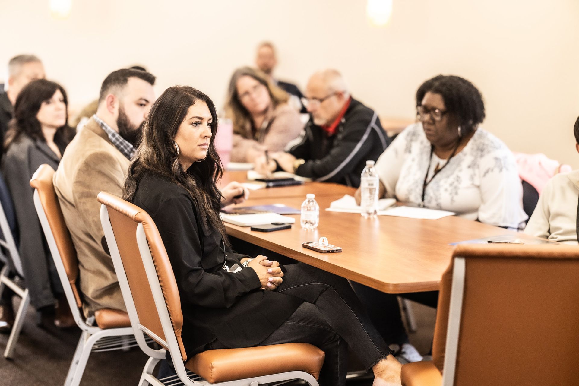 A group of people are sitting around a table having a meeting.