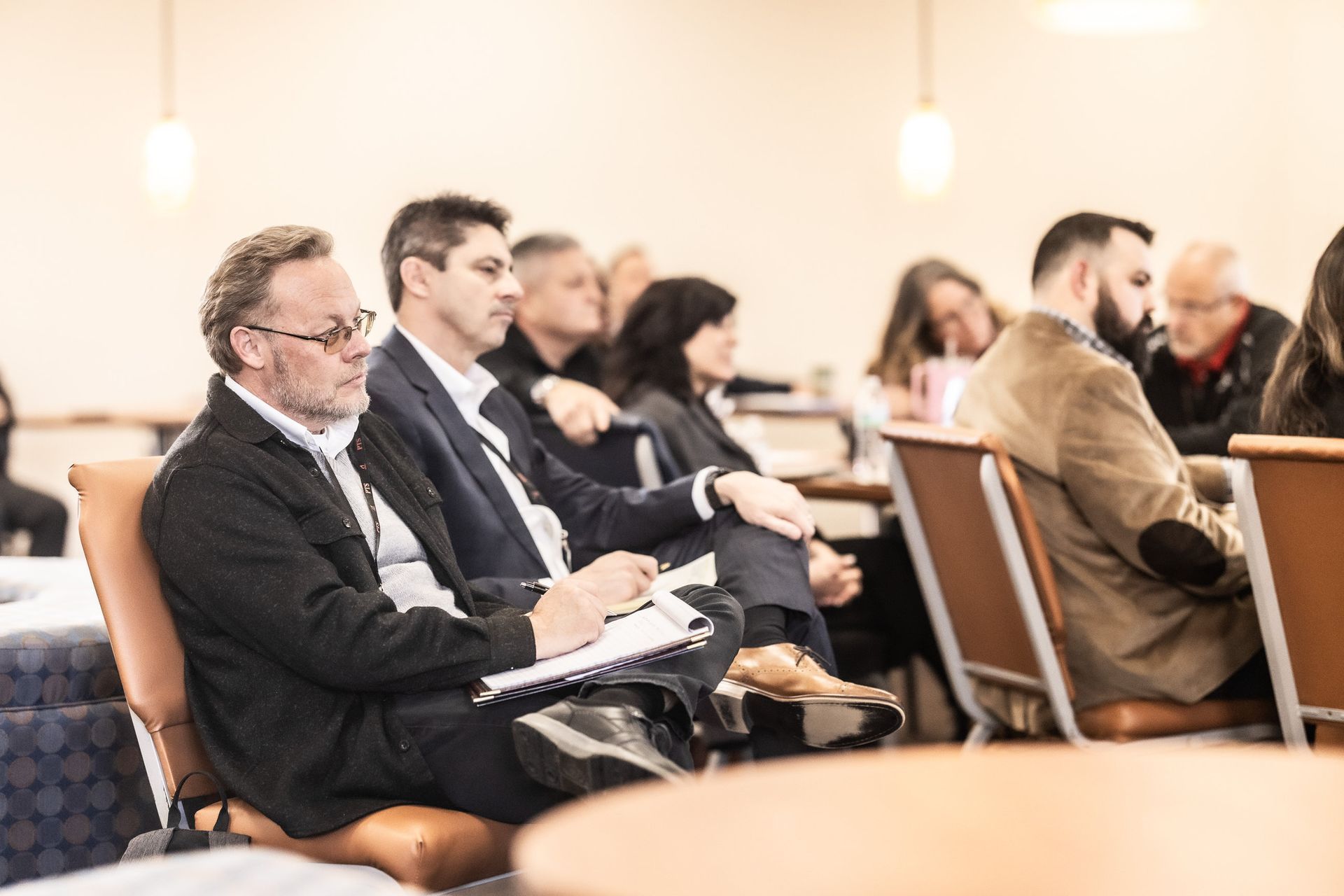 A group of people are sitting in chairs at a conference.