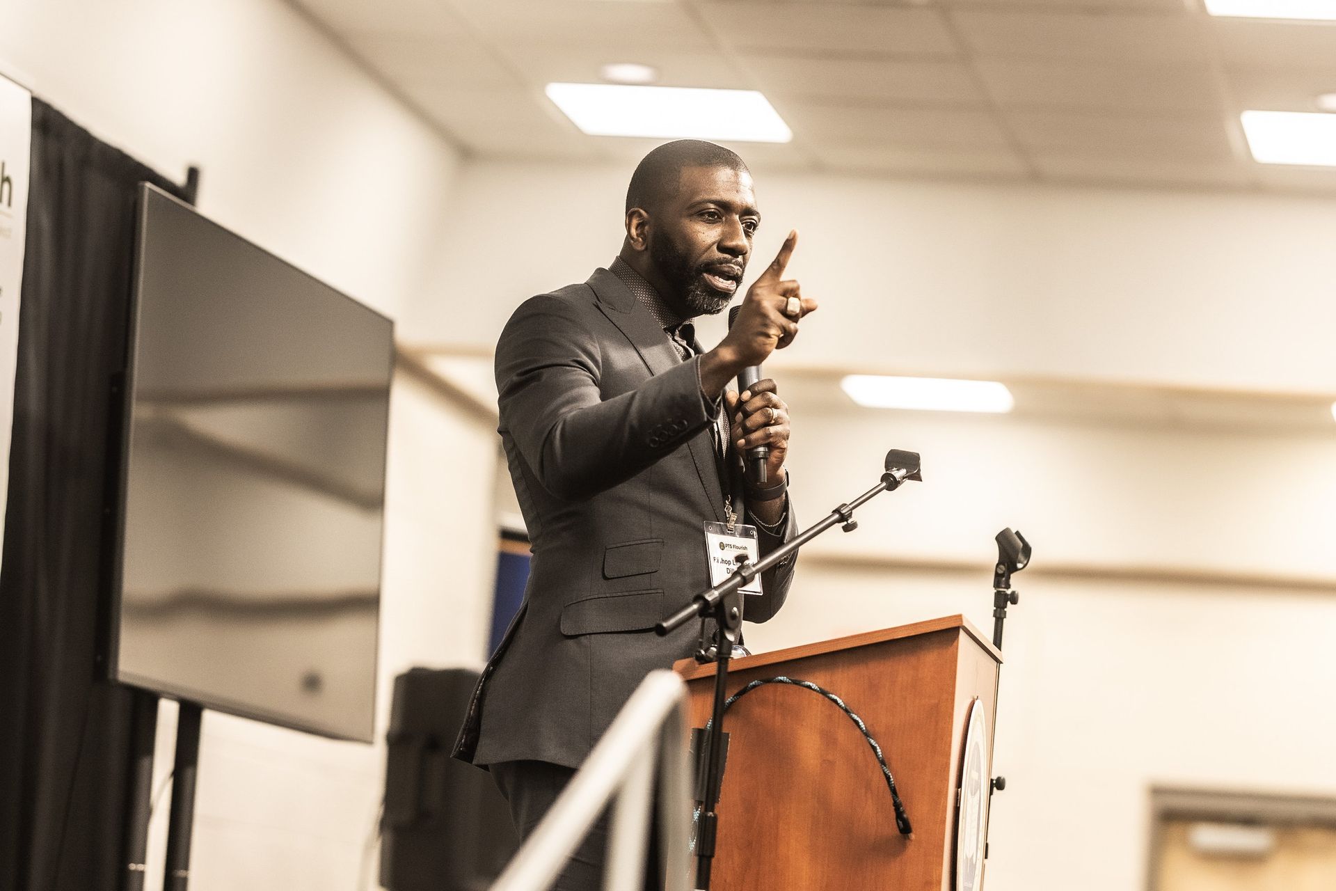 A man in a suit is standing at a podium giving a speech.