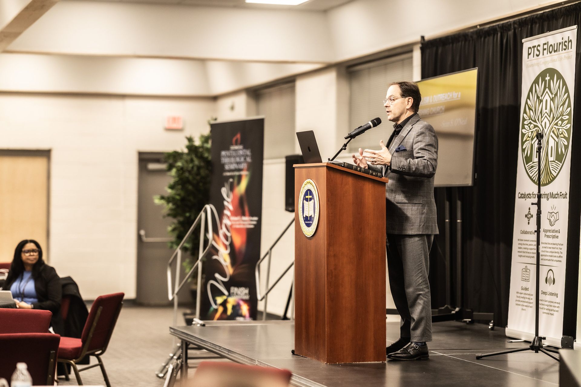 A man is standing at a podium giving a presentation.