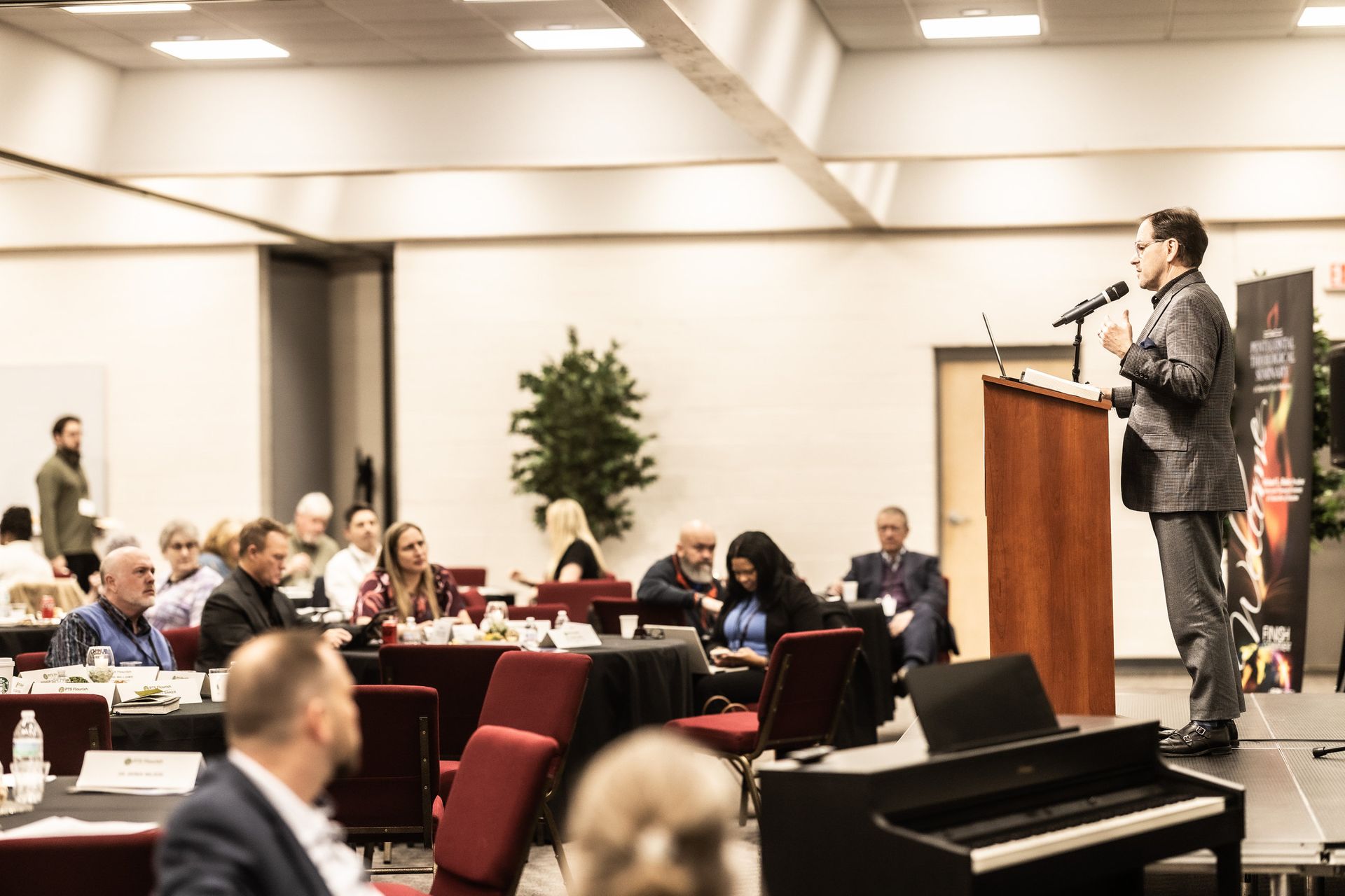 A man is standing at a podium giving a speech to a group of people.