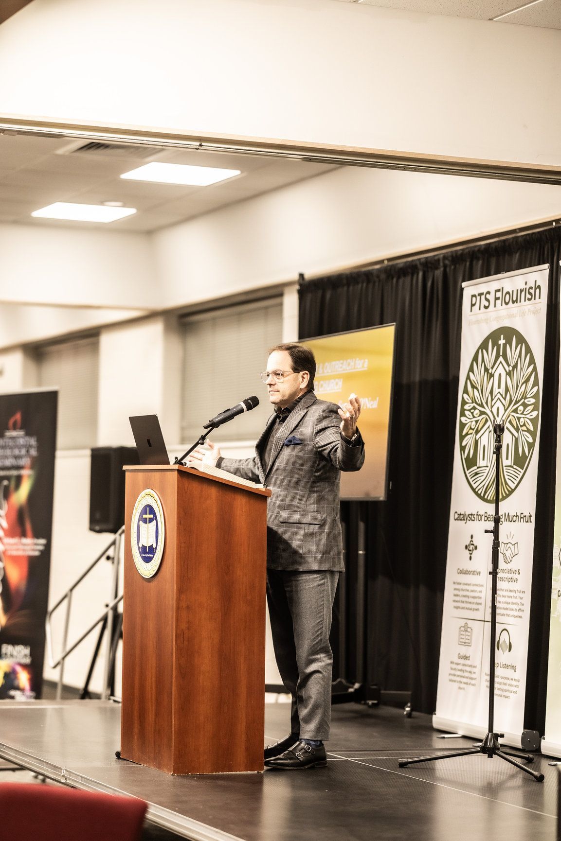 A man in a suit is standing at a podium giving a speech.