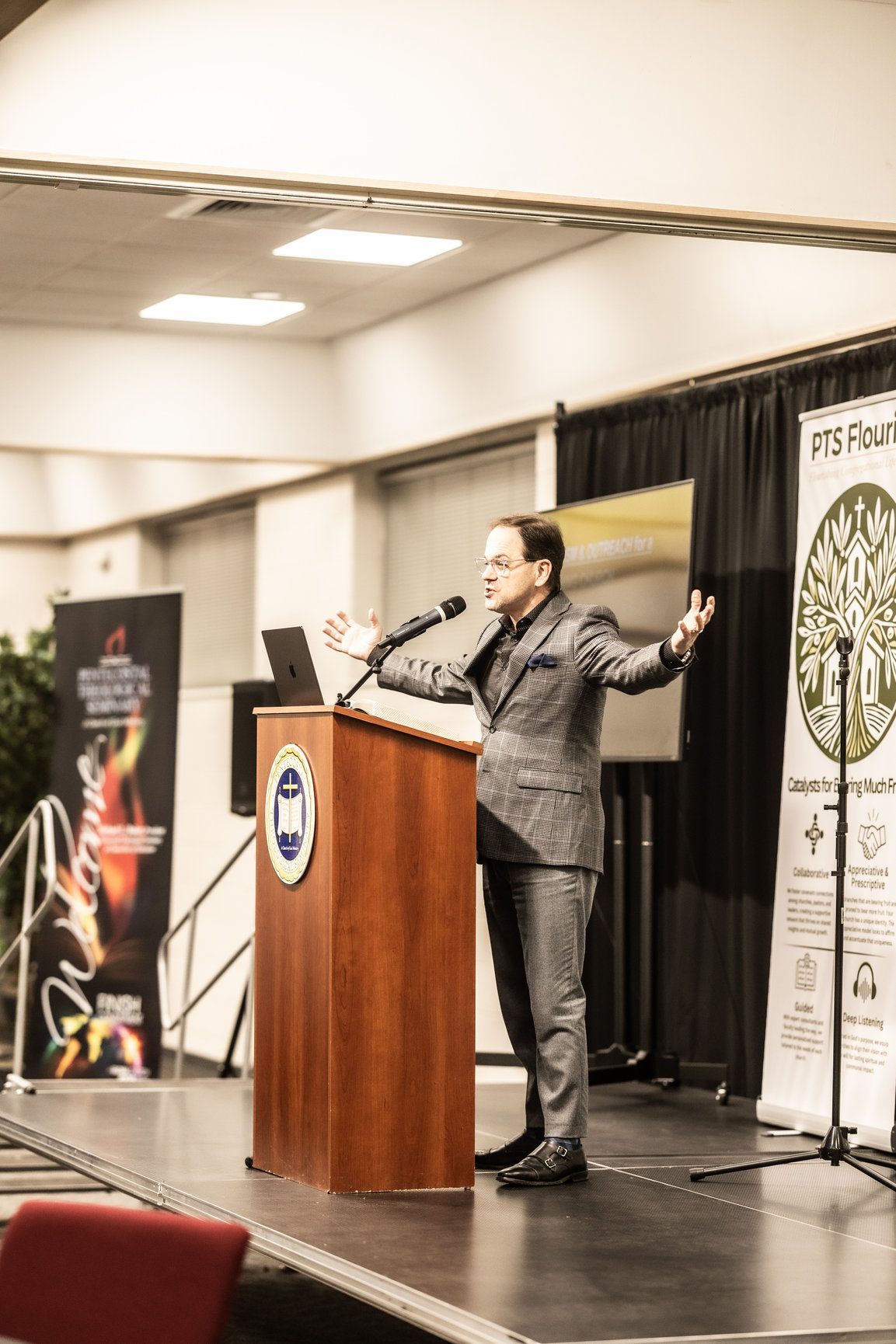 A man in a suit is standing at a podium giving a speech.