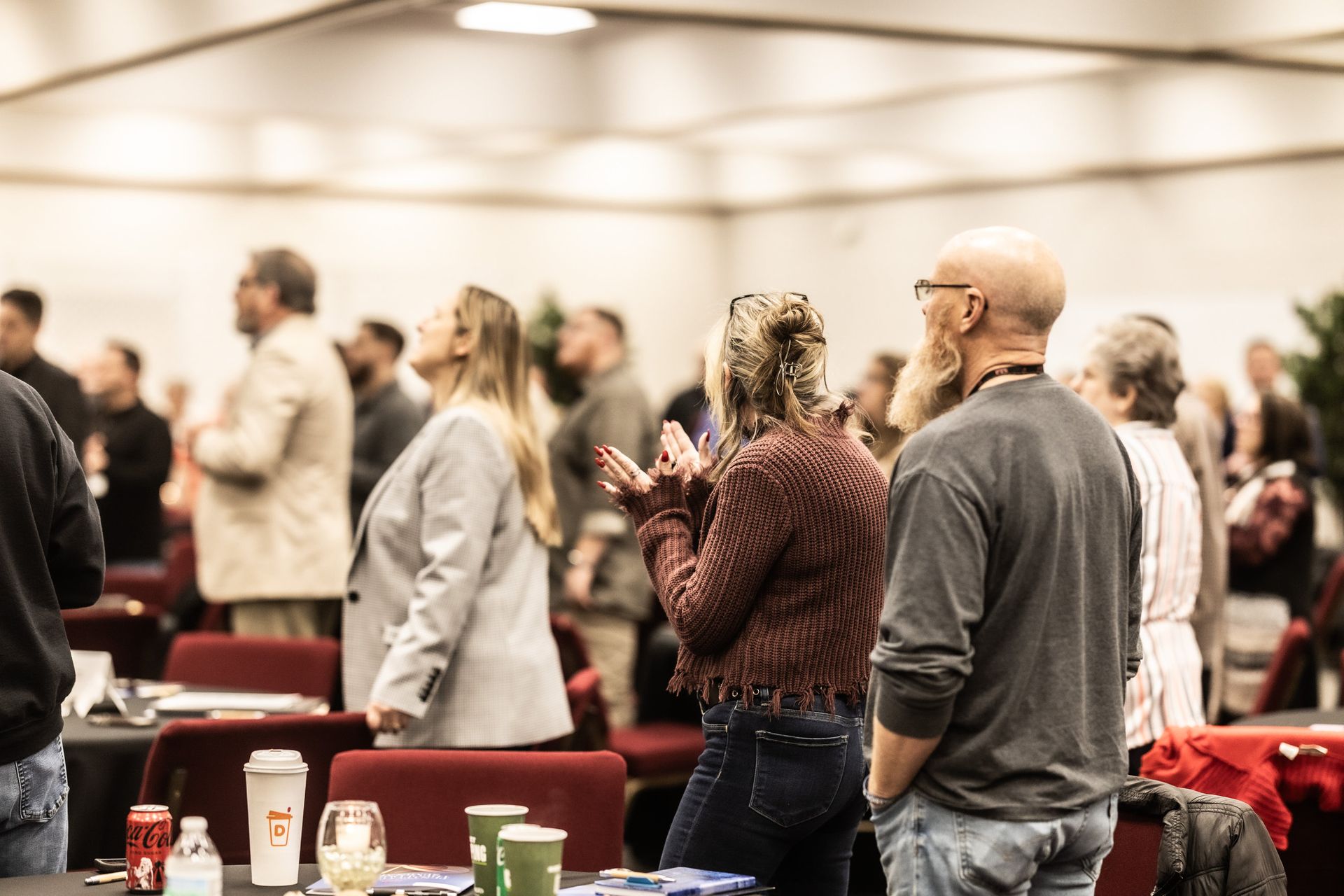 A group of people are standing in a room talking to each other.