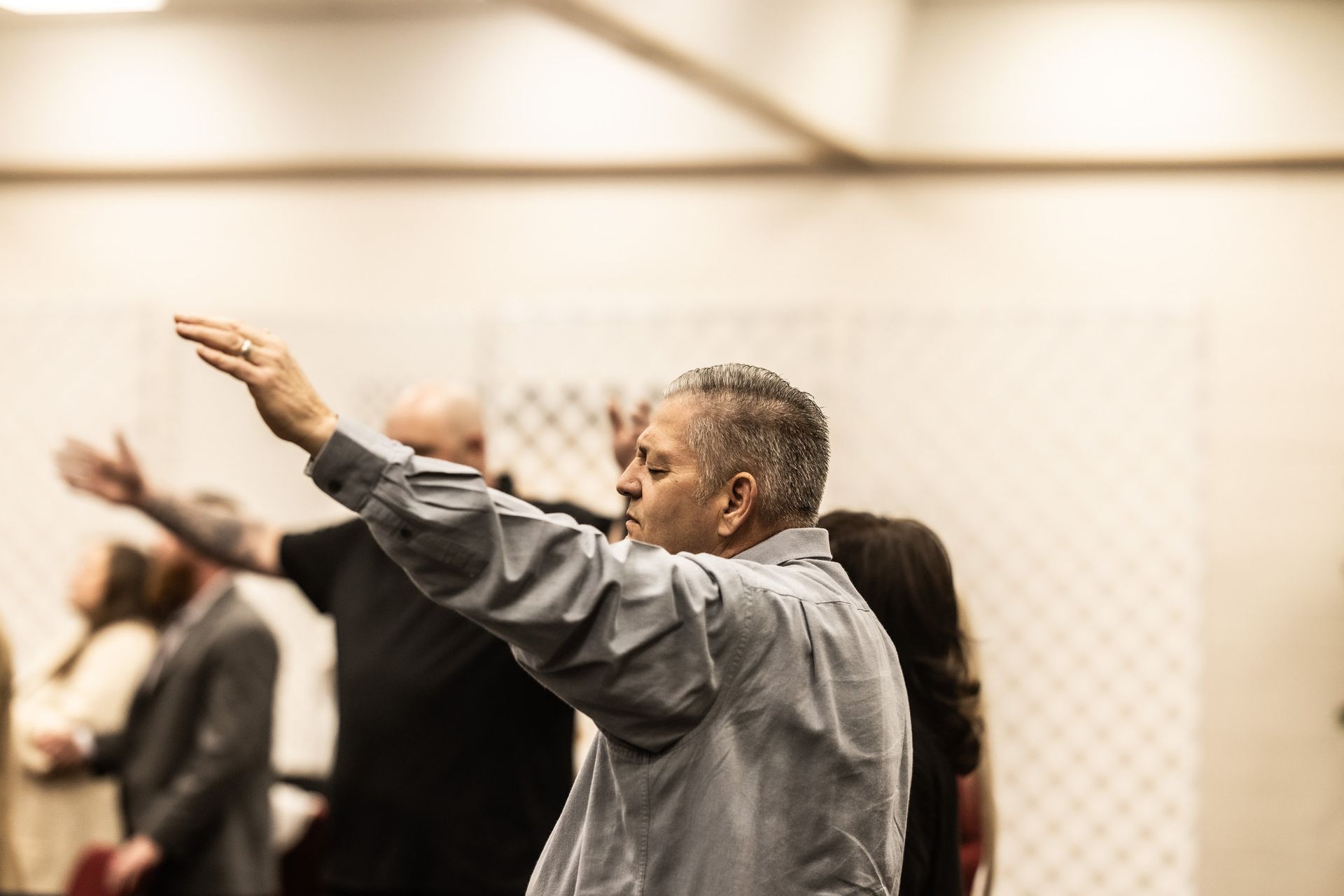 A man is standing in a room with his arms outstretched.