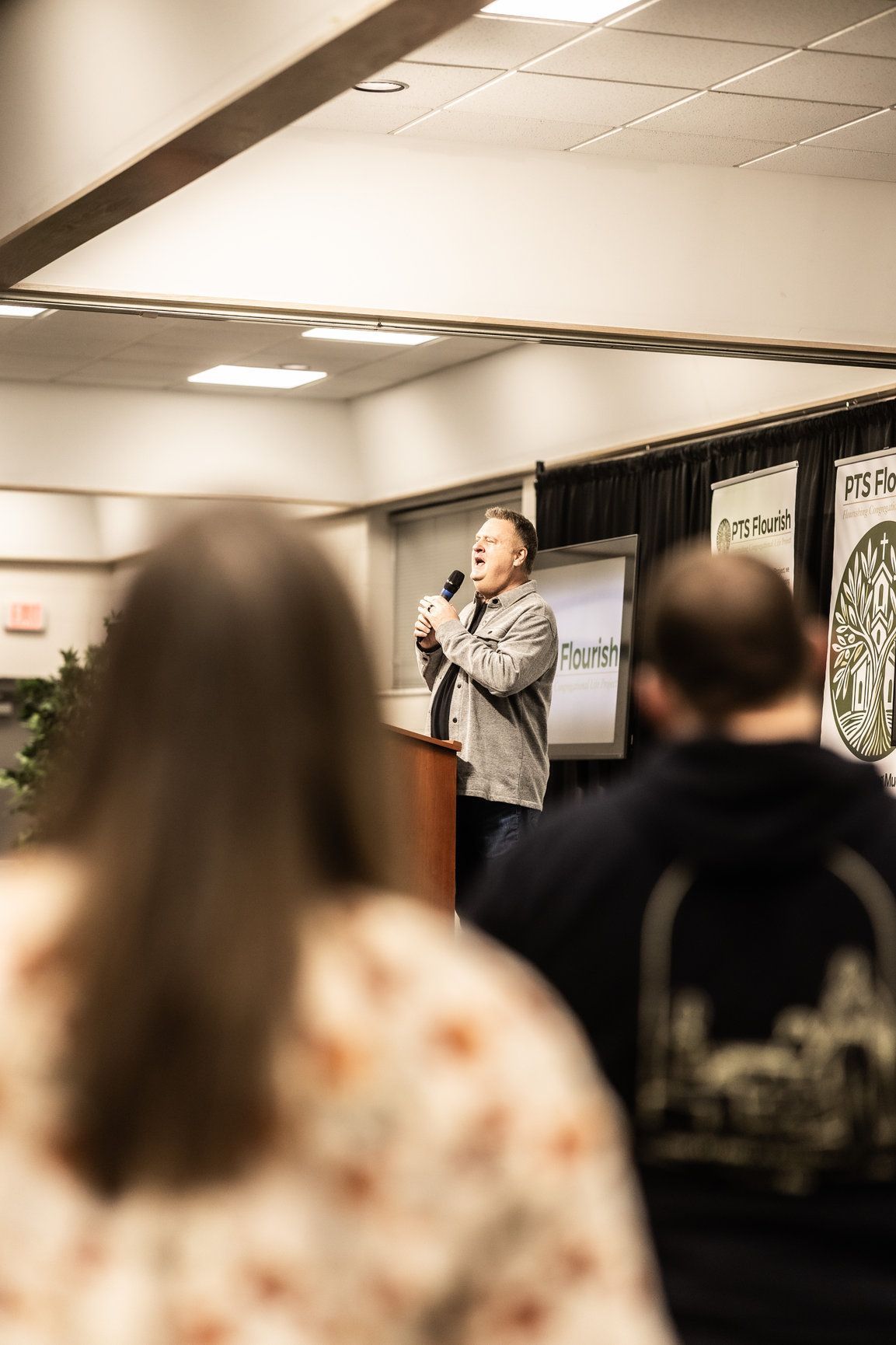A man is standing at a podium giving a speech to a group of people.